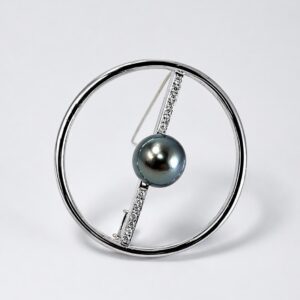 broche circulo pela de tahiti - Marisa Cano Silver circular hoop jewelry with a diagonal diamond-studded bar holding a dark grey-blue pearl centerpiece.