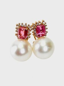 Gold-tone stud earrings featuring large white pearls and pink square-cut stones surrounded by small diamonds.